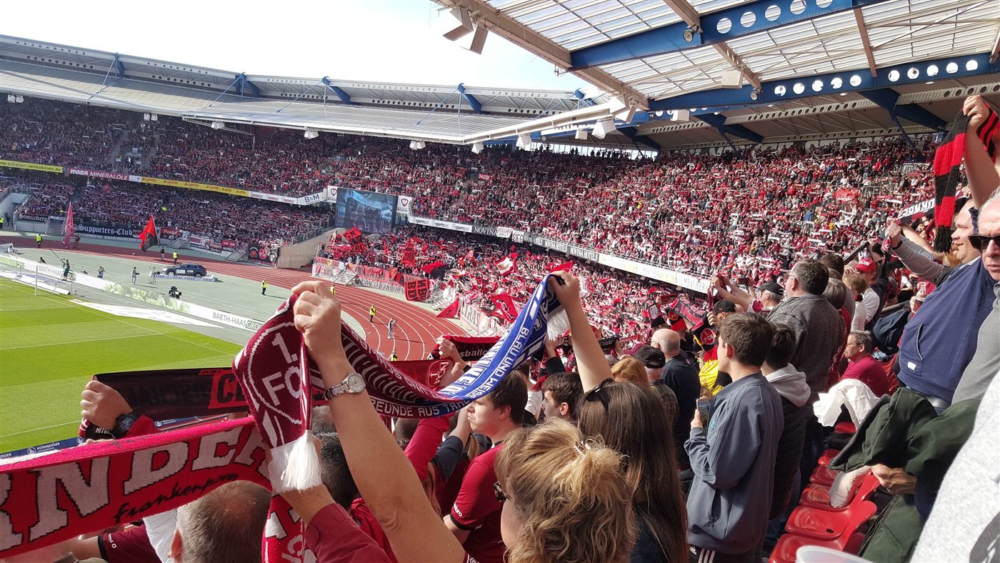 Club-Fans mit Schal auf der Stadiontribüne